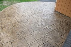 an outdoor patio with stone pavers and grass in the background