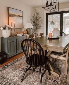 a dining room table with chairs and a rug on the floor in front of it