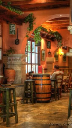 the interior of a restaurant with tables and stools