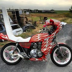 a red and white motorcycle parked on top of a gravel road