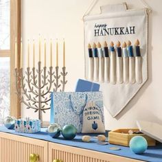 a hanukkah menorah banner hangs on the wall above a mantle