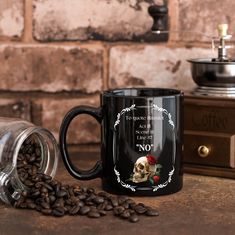 a black coffee mug with a skull and roses on it next to some coffee beans