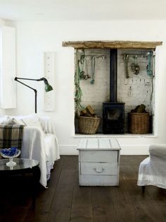 a living room filled with furniture and a fire place next to a wall mounted oven