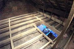 the inside of an old building with wooden floors and beams in place to support it