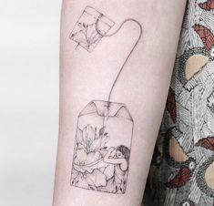 a woman's arm with a flower in a vase tattoo on the left forearm