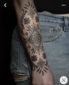 a woman's arm with a tattoo on it that has flowers in the middle