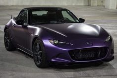 a purple sports car parked in an empty parking lot