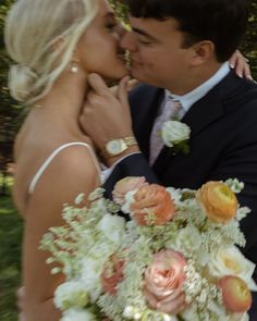 a bride and groom kissing in front of trees