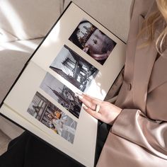 a woman sitting on a couch holding an open book