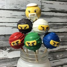 there are six lego head cake pops on the stick