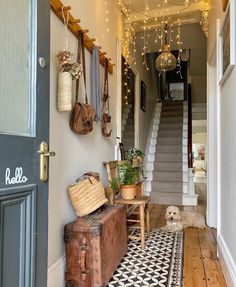 the hallway is decorated with hanging lights and baskets on the wall, along with an old trunk