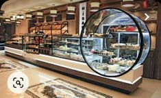 the inside of a bakery with lots of cakes and pastries on display in it