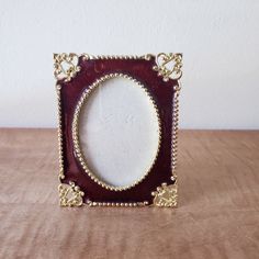 a red and gold frame sitting on top of a wooden table