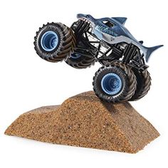 a toy truck that is on top of a rock in the air with it's wheels up