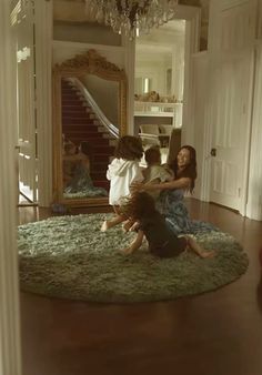 a group of young children sitting on top of a rug in front of a mirror