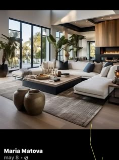 a living room filled with lots of furniture and large windows overlooking the water in front of it