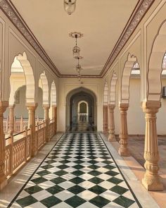 an ornate hallway with columns and checkered flooring