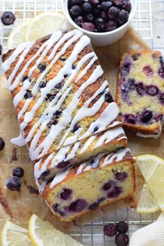 blueberry lemon bread with icing on a cutting board next to sliced lemons