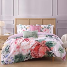 a bed with pink and green flowers on it