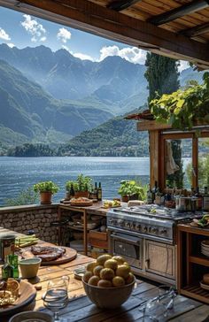 an outdoor kitchen with mountains in the background and a table full of food on it