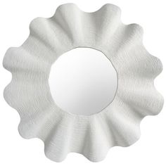 a white flower shaped mirror hanging on the side of a wall in front of a white background