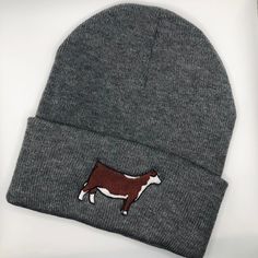 a gray beanie with a brown and white cow on it