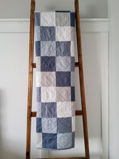 a blue and white quilt hanging on a ladder