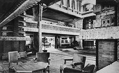 an old black and white photo of the inside of a building with chairs and tables