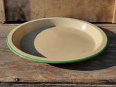 a green and white bowl sitting on top of a wooden table