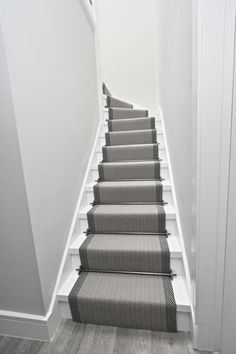 a set of stairs leading up to the top floor in a house with white walls