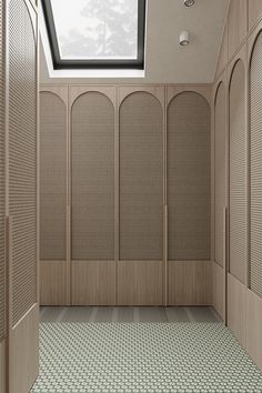 an empty room with several wooden lockers and skylight in the ceiling above it