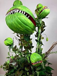 an arrangement of green plants with monster heads on them