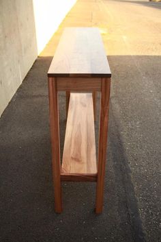 a wooden table sitting on the side of a road