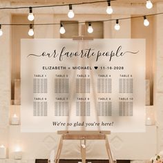 a wedding seating chart is displayed on a easel in front of candles and flowers