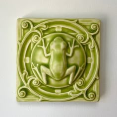 a green tile with a frog on it