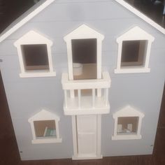 a white doll house with windows and doors