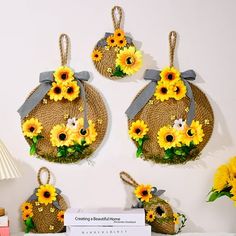 four sunflowers are hanging on the wall in front of a sign and lamp