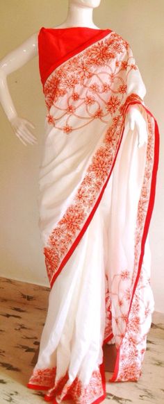 "Stunning half white semi silk saree with intricate all over embroidery and semi raw silk unstiched blouse in reddish orange. The red color thread embroidery is simply stunning aginst offwhite. The entire embroidery is hand worked and the floral border extends more in the front, pallu and the pleats. Saree length 5.5 meters Blouse fabric 1 meter 44\" wide Saree ships in 2-3 days of payment. Delivery within 4-5 days of shipment all over the world. We also offer blouse and petticoat stitching for Traditional White Pre-draped Saree With Embroidered Border, Embroidered White Pre-draped Saree For Festivals, White Silk Pre-draped Saree For Festivals, White Silk Traditional Wear With Floral Embroidery, White Cutdana Pre-draped Saree For Puja, White Floral Embroidered Pre-draped Saree For Wedding, Traditional Red Embroidered Pre-draped Saree, Traditional Red Pre-draped Embroidered Saree, Red Chanderi Pre-draped Saree With Embroidered Border