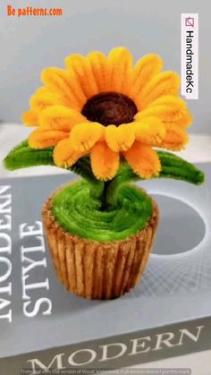 a cupcake with green icing and a yellow flower