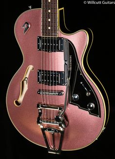 an electric guitar with a pink body and gold hardware on it's neck, in front of a black background