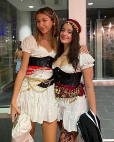 two young women dressed in costumes posing for the camera with their arms around each other