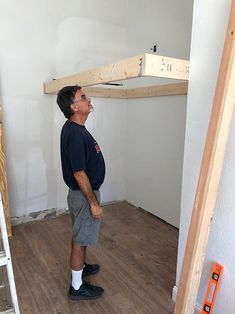 a man standing in the middle of a room under construction