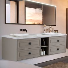 a bathroom with two sinks and mirrors on the wall