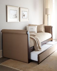 a day bed with a pull out trundle and pillows on it in a bedroom