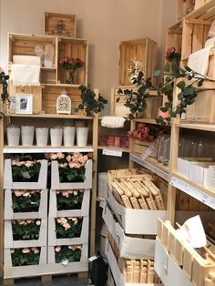 a room filled with lots of wooden crates and flowers on shelves next to each other