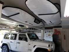 a white jeep is parked in a garage