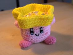 a crocheted toy with a yellow crown on it's head sitting on a table