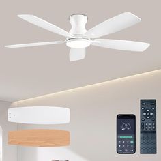 a white ceiling fan sitting above a bed next to remote controls