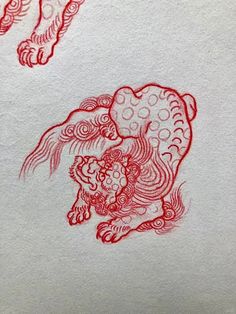 two red ink drawings of lions on white paper