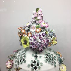 a white vase filled with lots of colorful flowers